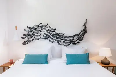 a bedroom with a large bed with blue pillows at Avra Apartments Venetian Harbour in Chania Town