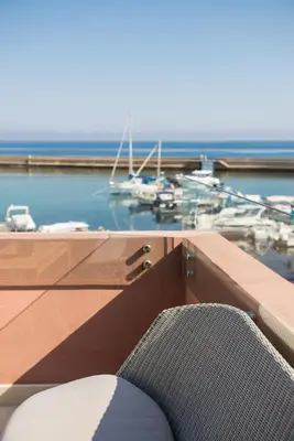a chair sitting on top of a balcony with a marina at Avra Apartments Venetian Harbour in Chania Town