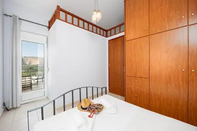 a bedroom with a bed and a large window at Villa Dimitris in Vlikhádha