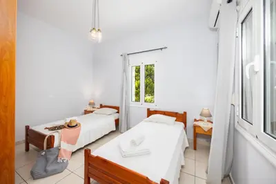 a bedroom with two beds and a window at Villa Dimitris in Vlikhádha