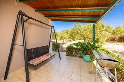 a porch with a swing and a roof at Villa Dimitris in Vlikhádha