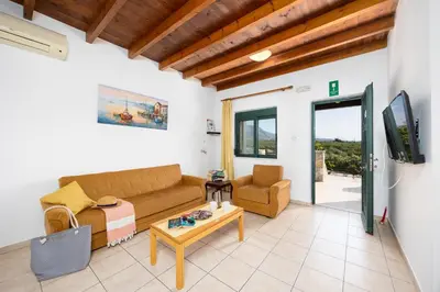 a living room with a couch and a tv at Theo Beach Villa in Frangokastello