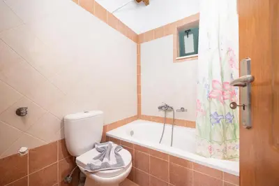 a bathroom with a toilet and a bath tub at Theo Beach Villa in Frangokastello
