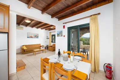 a kitchen and living room with a table and chairs at Theo Beach Villa in Frangokastello