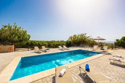 a swimming pool with chaise lounge chairs and a pool at Theo Beach Villa in Frangokastello