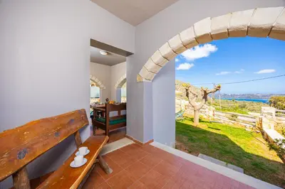 a room with a bench and a view of the ocean at Villa Neria in Áptera