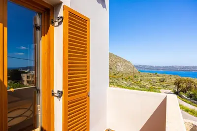 a door to a balcony with a view of the ocean at Villa Neria in Áptera