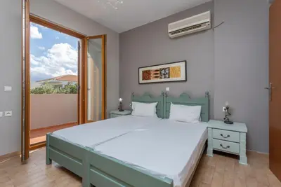 a bedroom with a large bed and a window at Villa Konstantina in Exopoli