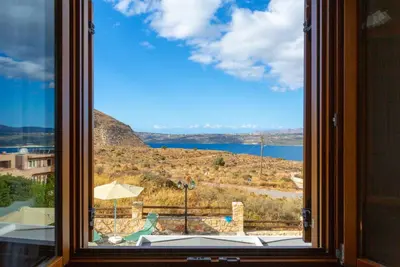 a window with a view of a mountain and a lake at Villa Konstantina in Exopoli