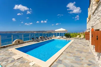 a swimming pool with a view of the water at Souda Bay View in Kalami