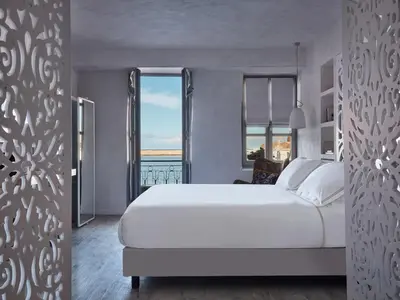 a bedroom with a large white bed and a large window at Domus Fresco in Chania Town