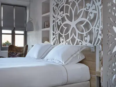 a bedroom with a white bed and a wall at Domus Fresco in Chania Town