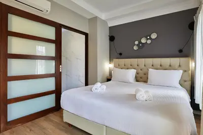 a bedroom with a white bed with towels on it at Nival Luxury Suites in Chania Town