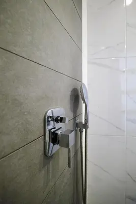 a shower head on a wall in a bathroom at Nival Luxury Suites in Chania Town