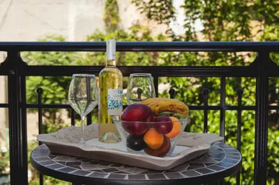 a tray with a bowl of fruit and a bottle of wine at Nival Luxury Suites in Chania Town