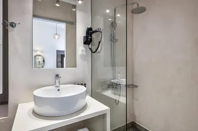 a white bathroom with a sink and a shower at Shalom Luxury Rooms Daliani in Chania Town