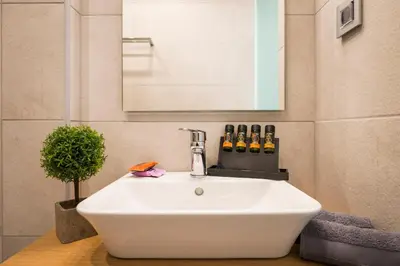 a white sink in a bathroom with a mirror at Central City Hotel in Chania Town