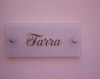 a sign on a pink wall with the word taria at Estrella Studios in Chania Town
