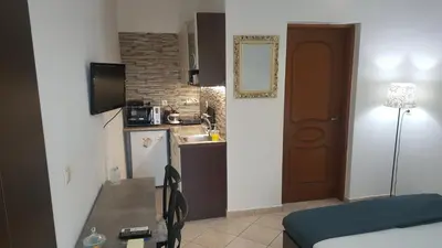 a small room with a kitchen and a table and a door at Estrella Studios in Chania Town