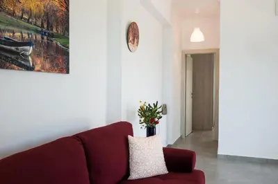 a living room with a red couch and a painting at Niovi Seaside Suites in Kissamos