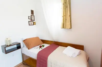 a small bedroom with a bed and a window at Ortaki Traditional House in Loúlos