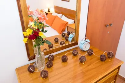 a table with a vase of flowers and a mirror at Ortaki Traditional House in Loúlos