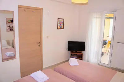 a bedroom with two beds and a television in it at Olive Tree Hillside Apartment in Stalos