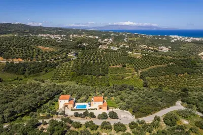 an aerial view of a house on a hill next to the ocean at Olive Tree Hillside Apartment in Stalos