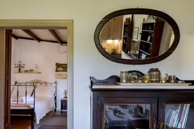 a mirror on a wall above a fireplace in a bedroom at The Olive House in Kondomari