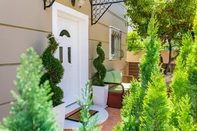 a front porch with a white door and green plants at Villa Galata in Galatás