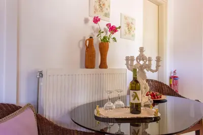 a glass table with two glasses and a bottle of wine at Villa Galata in Galatás