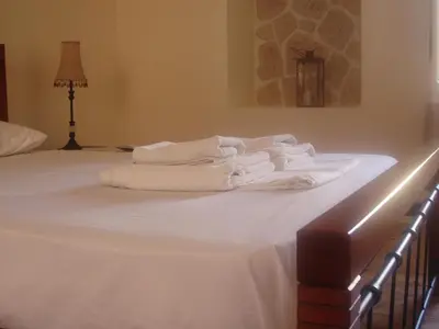 a bed with white towels stacked on top of it at Chrynigema in Chania Town