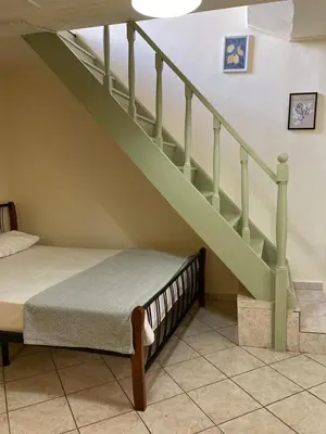 a bedroom with a bed and a stair case at Chrynigema in Chania Town