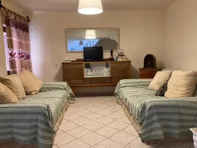 a living room with two beds and a flat screen tv at Chrynigema in Chania Town