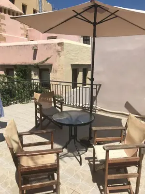 a patio with a table and chairs and an umbrella at Chrynigema in Chania Town
