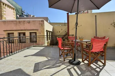 a patio with a table and chairs and an umbrella at Chrynigema in Chania Town