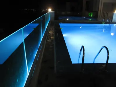 a swimming pool at night with lights in the water at Esplanade Apartments - Heated Pool in Kalathas