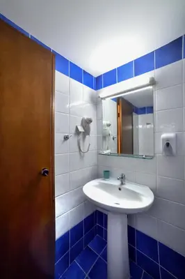 a bathroom with a sink and a mirror at Akatos Hotel in Agia Marina Nea Kydonias
