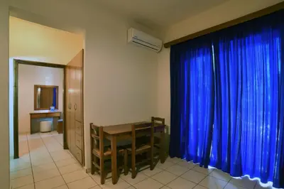 a room with a table and a blue curtain at Akatos Hotel in Agia Marina Nea Kydonias
