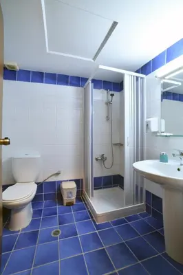 a bathroom with a toilet and a shower and a sink at Akatos Hotel in Agia Marina Nea Kydonias