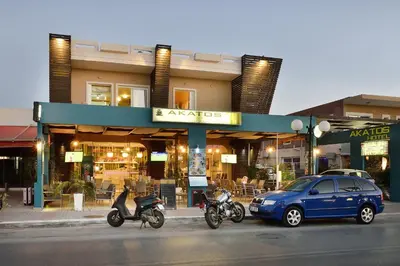 a car and motorcycles parked in front of a store at Akatos Hotel in Agia Marina Nea Kydonias