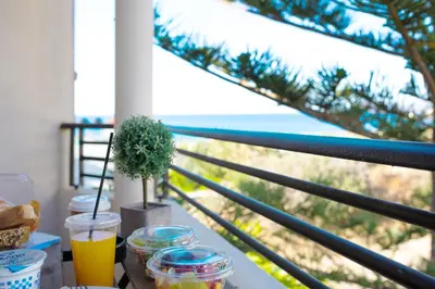 a table with a window with a view of the ocean at Yasmine Apartments and Rooms in Kato Daratso