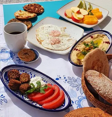 a table with plates of food and a cup of coffee at Yasmine Apartments and Rooms in Kato Daratso