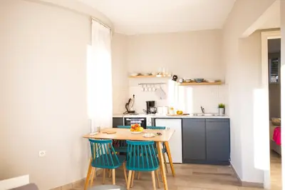 a small kitchen with a wooden table and chairs at Yasmine Apartments and Rooms in Kato Daratso