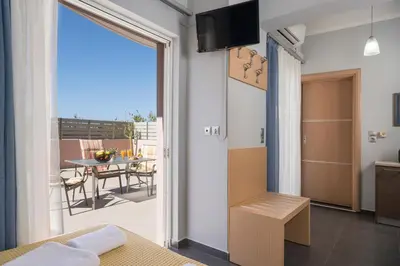 a bedroom with a sliding door to a balcony with a table at Astrantia in Chania Town
