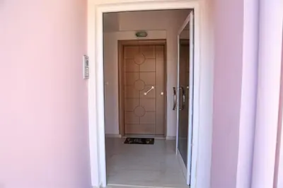a hallway with a door with a cat sitting in front of it at Astrantia in Chania Town