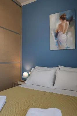 a bedroom with a bed with a painting on the wall at Astrantia in Chania Town