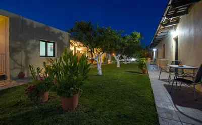 a yard with potted plants and a table at night at Studios Kydonia in Gerani Chanion