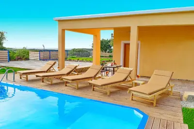 a patio with chairs and a swimming pool at White Lake Holiday House in Elafonisi