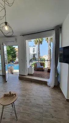 a living room with a sliding glass door and a table at Elizabeth Suites in Kato Daratso